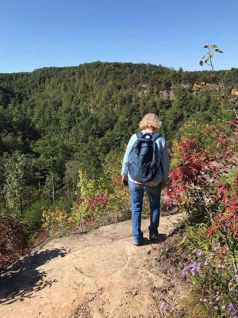 Jodi walking a mountainous trail 